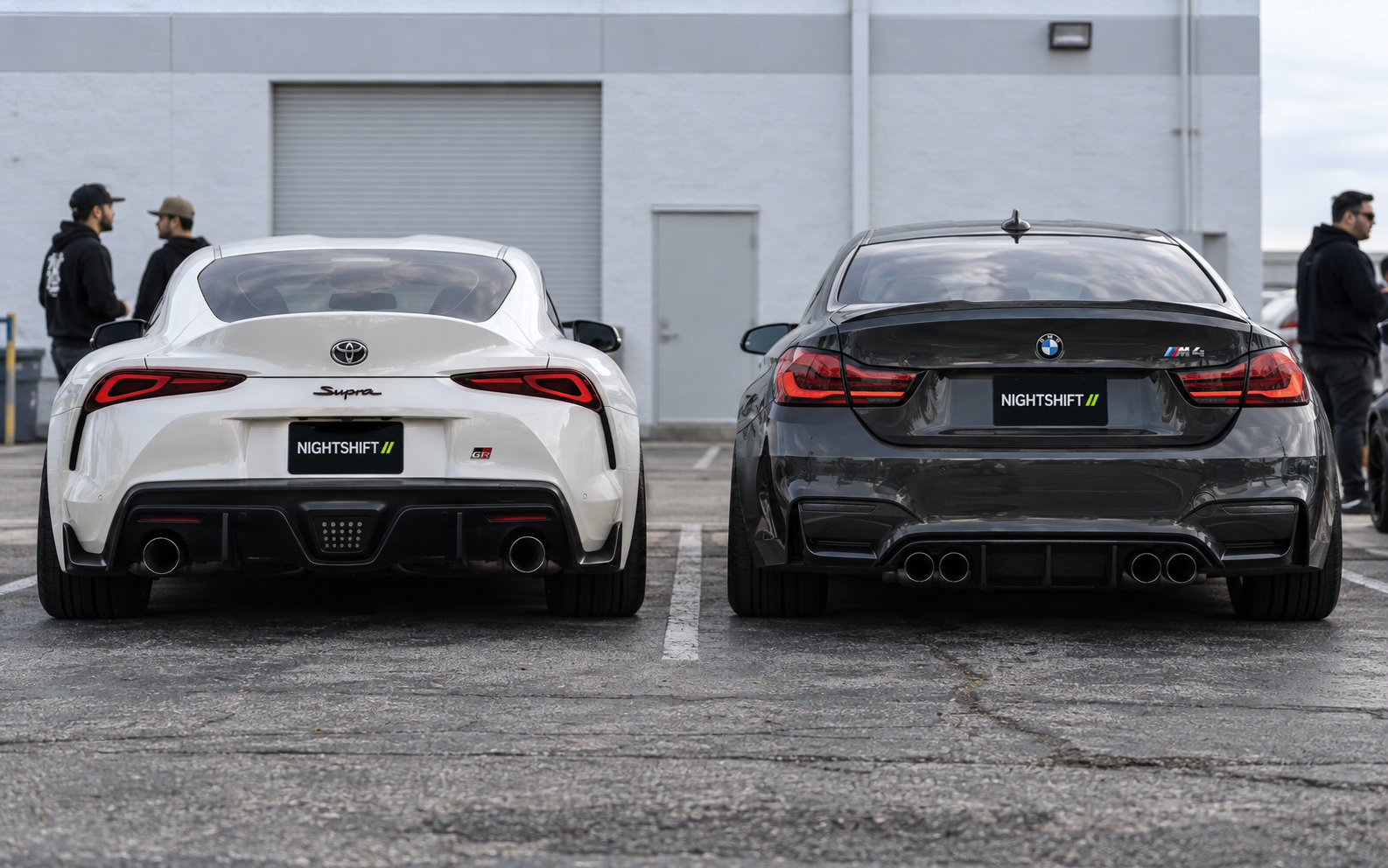 White Toyota Supra and gray BMW M4 with matching NIGHTSHIFT club plate covers