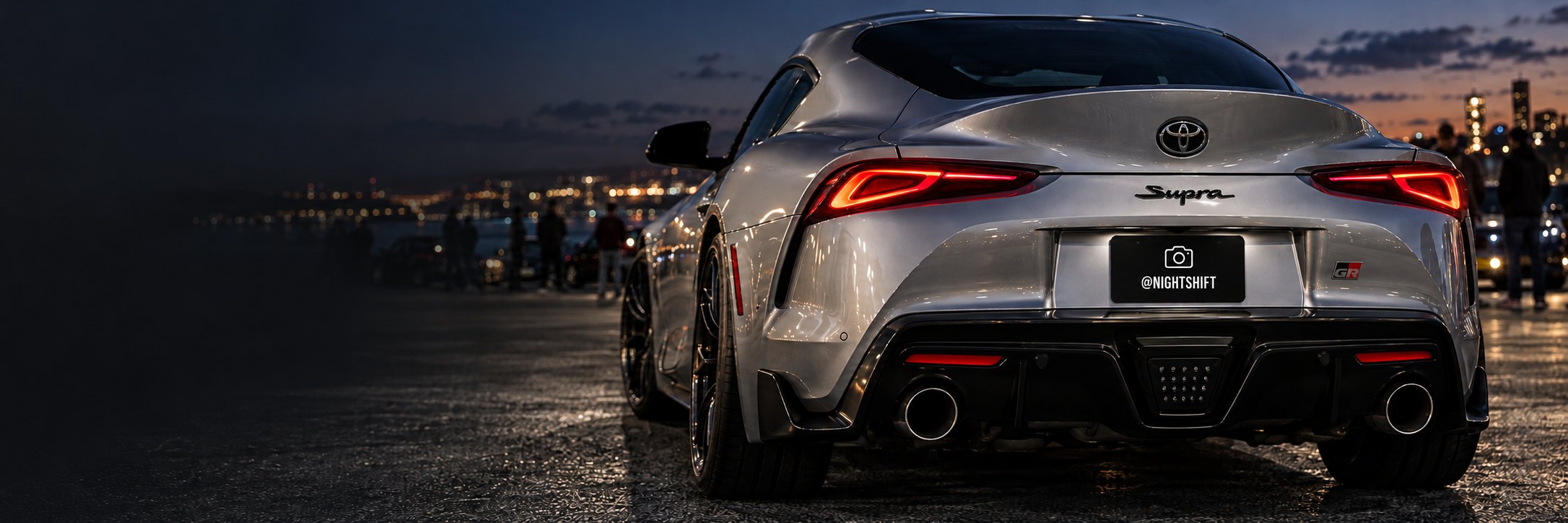 Silver Supra at a night meet with a Cover My Plate social plate cover
