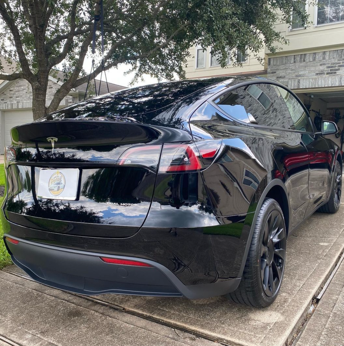 Black Tesla with a custom plate cover on the rear