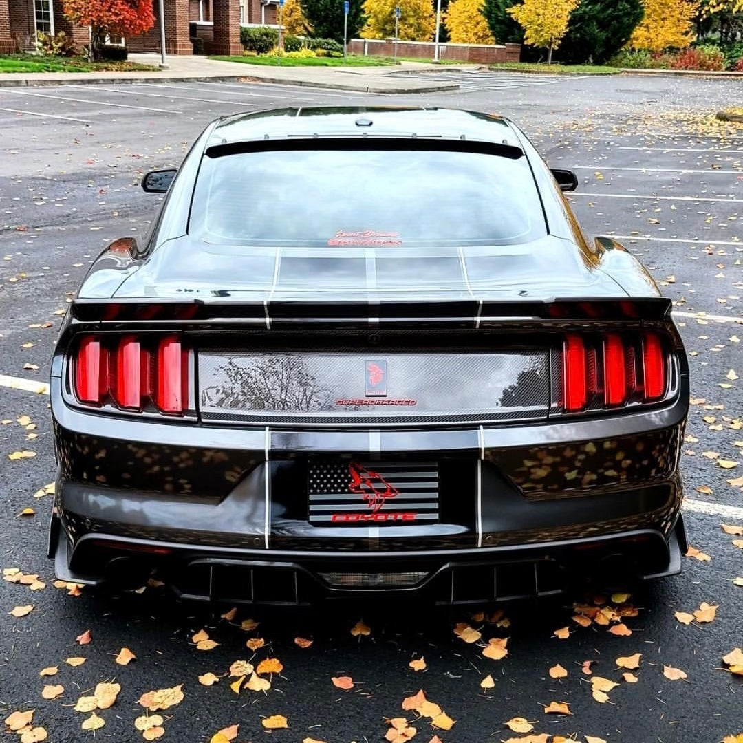 Grey Mustang with a Coyote flag plate cover at a car meet