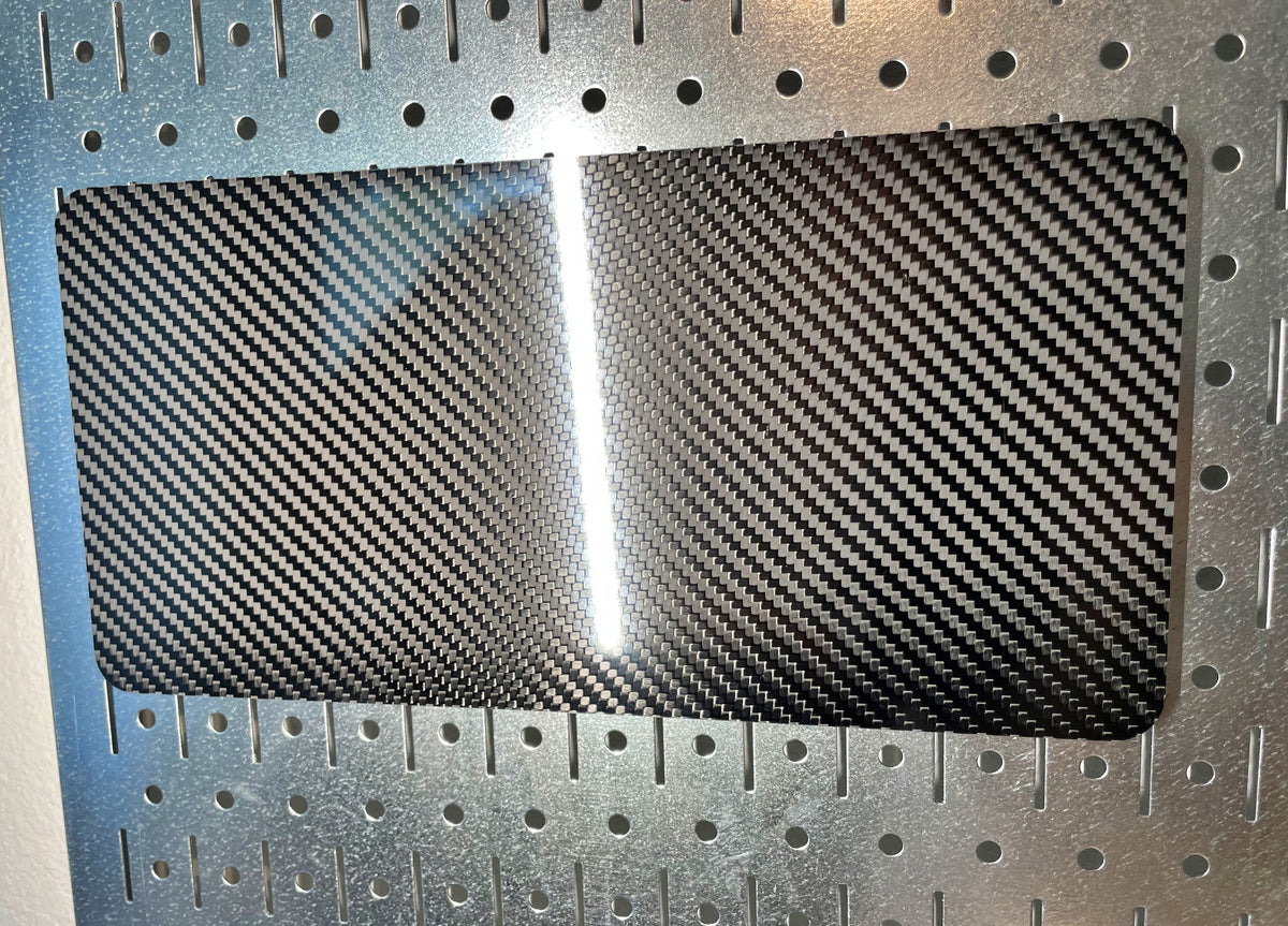 Real carbon fiber twill plate cover on a pegboard wall