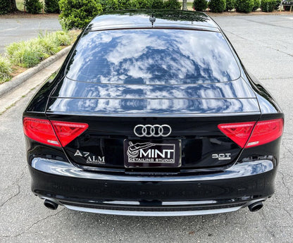 Black Audi with a custom detailing shop plate cover on the rear